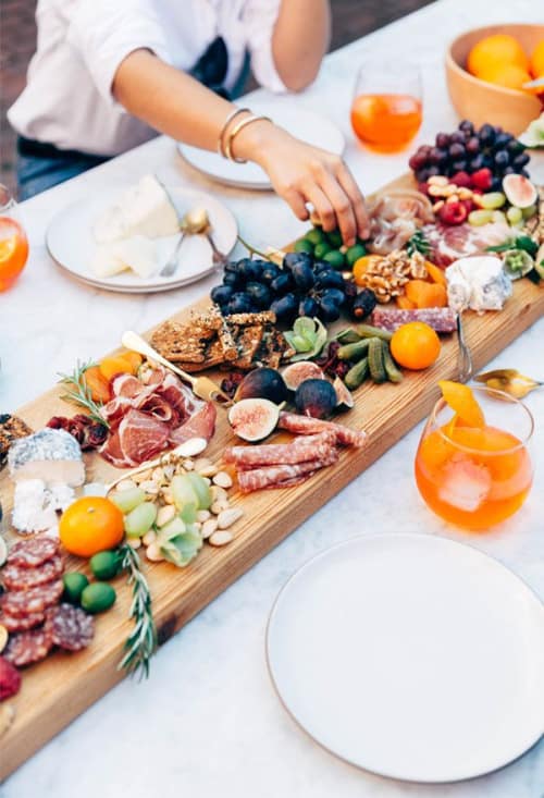 A big board of charcuterie cheese and fruit