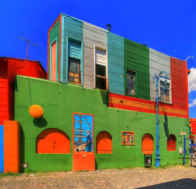 La Boca is a neighbourhood of Buenos Aires, the capital of Argentina. La Boca has many buildings made of scrap materials from the nearby shipyard that were painted lively with leftover paints from the same shipyard.